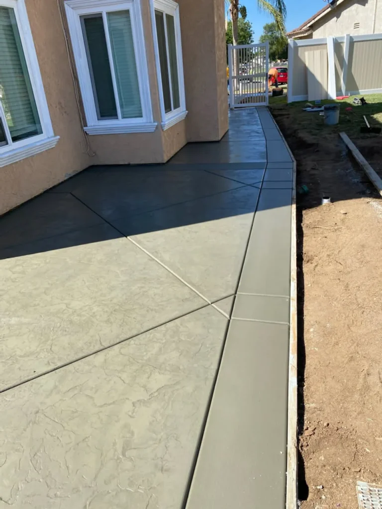 Concrete flatwork along the side of a house