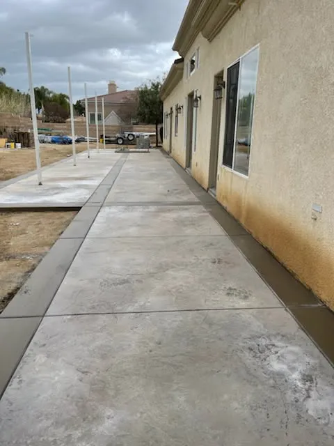 Long concrete sidewalk poured alongside a building