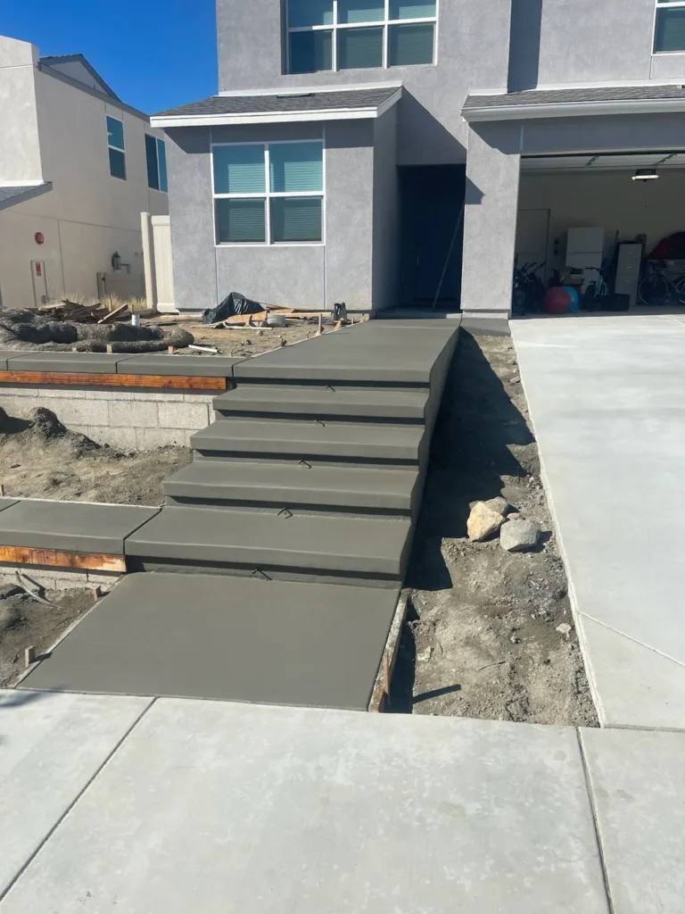 Concrete steps and walkway being formed at a two-story home